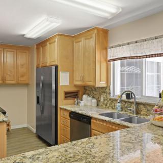 Modern kitchen with wooden cabinets and granite countertops.
