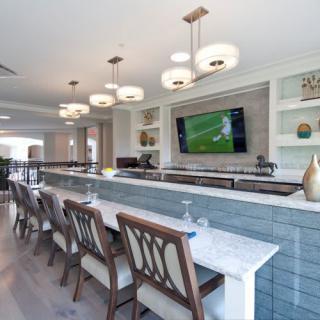A modern indoor bar with stylish seating and a television on the wall.