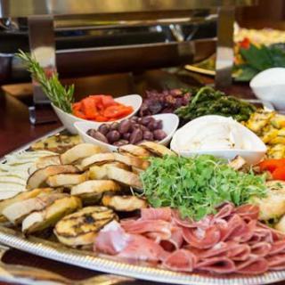 A beautifully arranged platter featuring a variety of grilled vegetables, meats, and cheese.