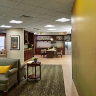 A cozy interior space with a living room and kitchen, featuring comfortable furniture and warm lighting.