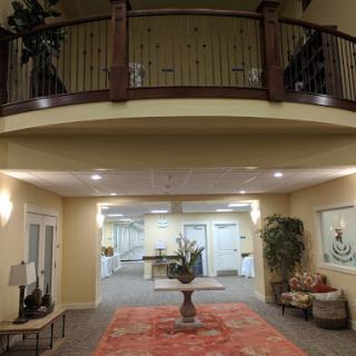 A spacious and elegantly designed lobby with a balcony, featuring modern decor and comfortable seating.