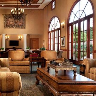 A luxurious hotel lobby with elegant furniture and large arched windows.
