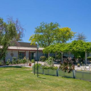 A sunny day view of a building surrounded by lush greenery and trees.