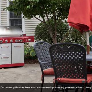A cozy patio setup with a red grill and umbrella, perfect for summer evenings.