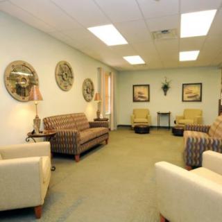 A cozy waiting room with sofas, chairs, and wall decor.