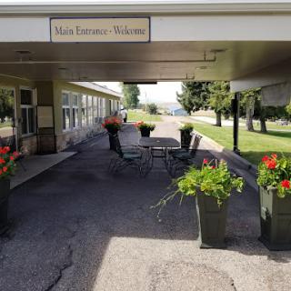 A welcoming entrance adorned with vibrant flowers and outdoor seating.