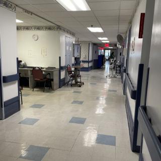 A clean and organized hospital corridor with medical equipment.