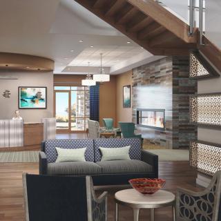 A modern living room with an open floor plan featuring stylish furniture and a wooden staircase.