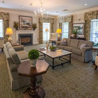 A cozy and elegantly designed living room with comfortable sofas, a central coffee table, and a warm fireplace.