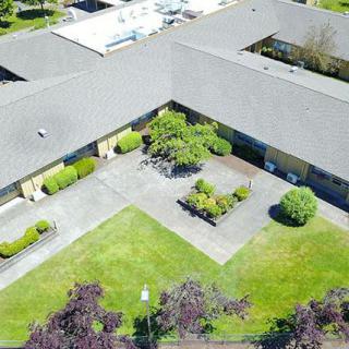 An aerial view of a building complex with a central courtyard surrounded by greenery.