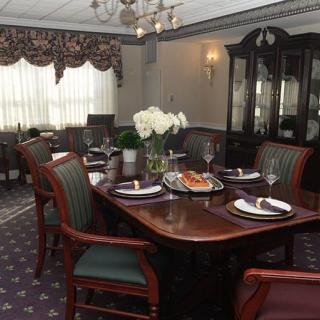 A classic-style dining room with an elegant table setting and a chandelier.