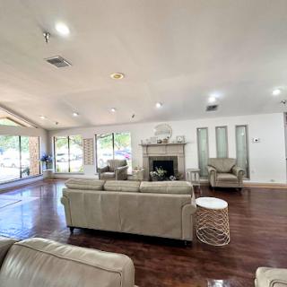 A spacious and modern living room featuring a cozy fireplace and large windows that invite natural light.