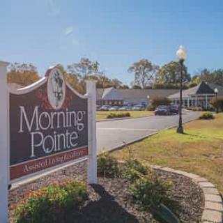 A scenic view of an assisted living facility with clear signage in front.