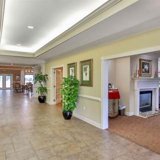 A spacious hallway leading to a living room featuring a fireplace and elegant decor.