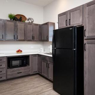 A modern kitchen featuring sleek cabinets and a black refrigerator.