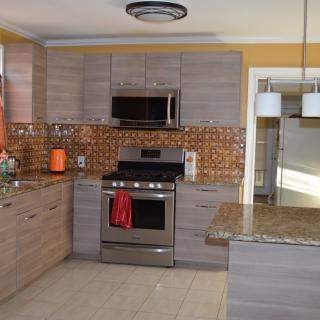 A modern kitchen with stainless steel appliances and a stylish backsplash.