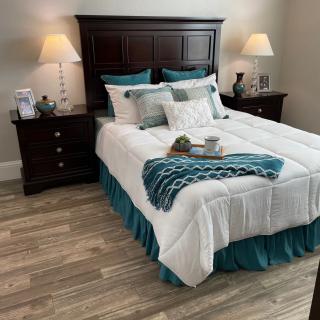 A cozy bedroom with a neatly made bed, side tables with lamps, and tasteful decor.