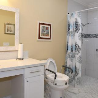 A modern and clean bathroom featuring a toilet, shower, and vanity.