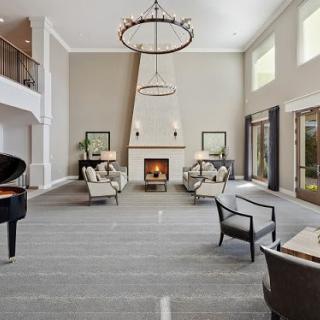 Spacious and elegant living room with a grand piano and a cozy fireplace.