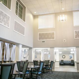 Modern lobby with high ceilings and dining furniture.