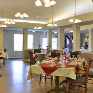 A well-decorated dining room with elegantly set tables and chairs, ready for guests.