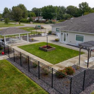 A view of a residential backyard featuring a well-maintained lawn, garden, and patio area.