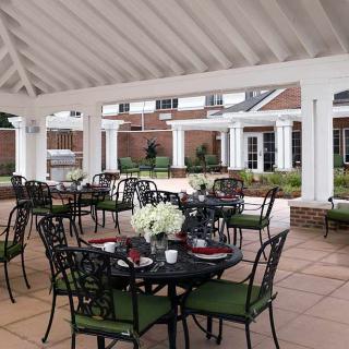 An inviting outdoor patio dining area under a gazebo with elegant tables and chairs.