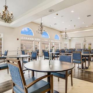 Elegant dining room interior with chandeliers and large windows.