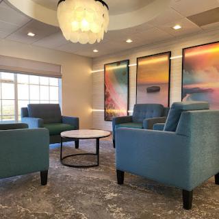 A cozy lounge area featuring modern furniture, decorative lighting, and vibrant artwork.