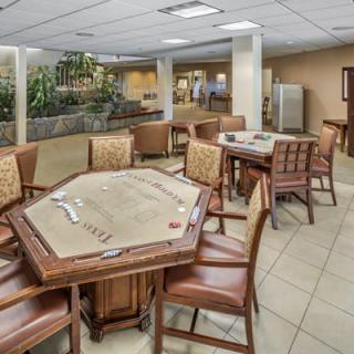 A spacious indoor game room featuring tables and chairs set up for recreational activities.