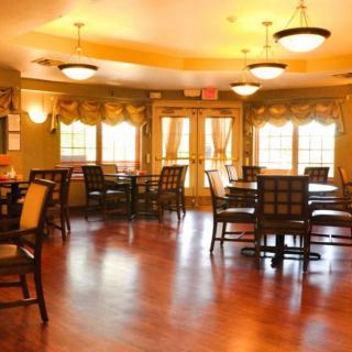 A cozy dining room with wooden floors and elegant lighting.