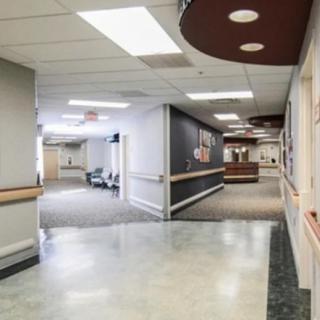 Empty hospital hallway with bright lighting and clean floors.