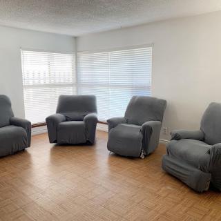 A cozy living room with four comfortable recliners arranged in a circle.