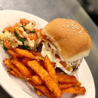 A delicious burger served with sweet potato fries.
