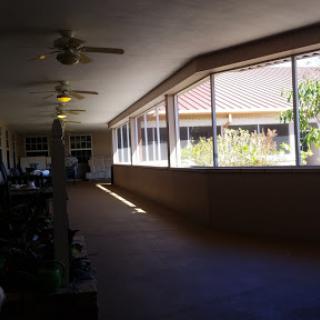 A sunlit hallway with windows and a view of greenery outside.