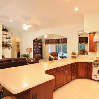 Spacious open-layout kitchen and living area with wooden cabinetry and modern appliances.