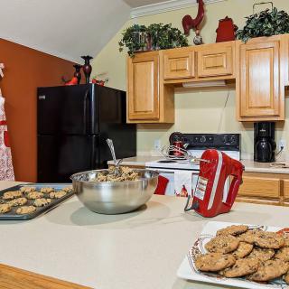 A cozy kitchen setting with freshly baked cookies on the countertop, accompanied by a mixer and baking supplies.