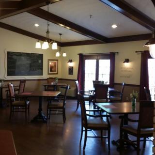 A cozy restaurant interior with wooden beams, tables, and chairs.