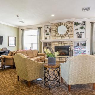 A cozy living room featuring a modern fireplace, comfortable seating, and elegant decor.