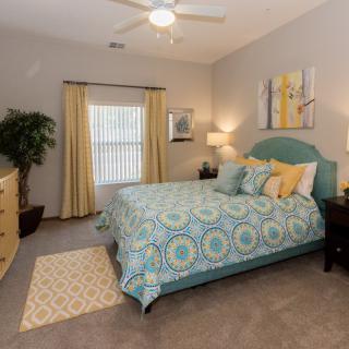 A well-decorated bedroom with a stylish bed, artwork, and cozy lighting.