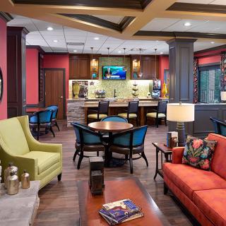 A modern lounge with vibrant seating, a coffee table, and a TV setup.