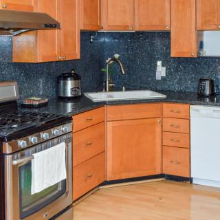 A modern kitchen with wooden cabinets and various appliances.