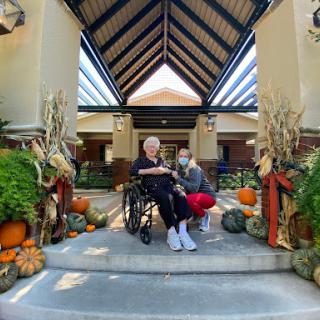 A heartwarming scene of companionship amidst festive autumn decorations.