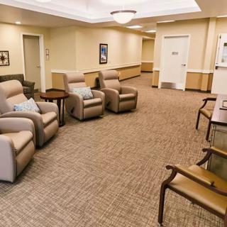 A waiting room with comfortable recliner chairs and a carpeted floor.