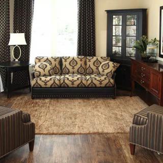 A cozy living room with a patterned sofa, armchairs, and elegant decor.