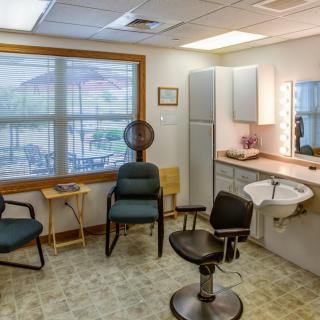 A cozy salon interior with chairs, a mirror, and a sink.