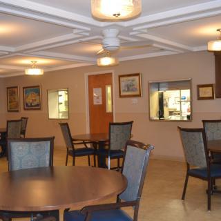 A well-lit dining area with tables and chairs arranged for visitors.