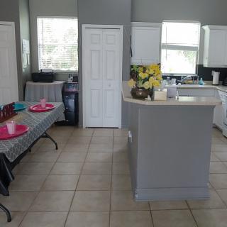 A modern kitchen interior with tiled floors and a central island.