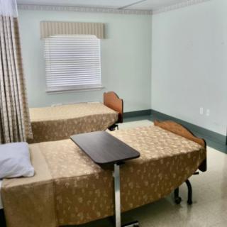 A clean hospital room with two beds and privacy curtains.