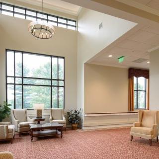 A spacious lobby area with ample seating and large windows providing natural light.